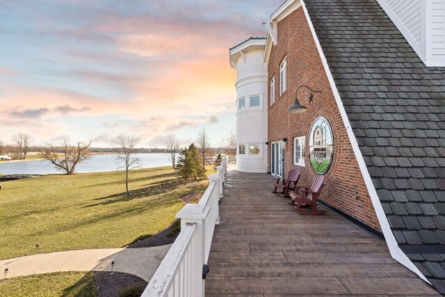 exterior space featuring a lawn and a water view