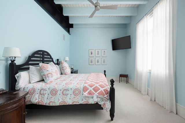 bedroom with light carpet, ceiling fan, beamed ceiling, and baseboards