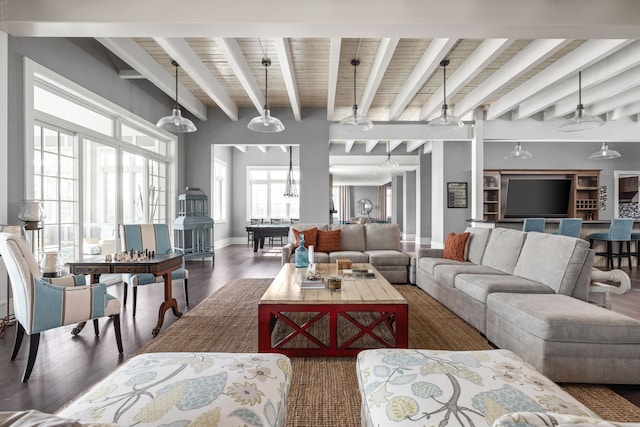 living room with beam ceiling, baseboards, and wood finished floors