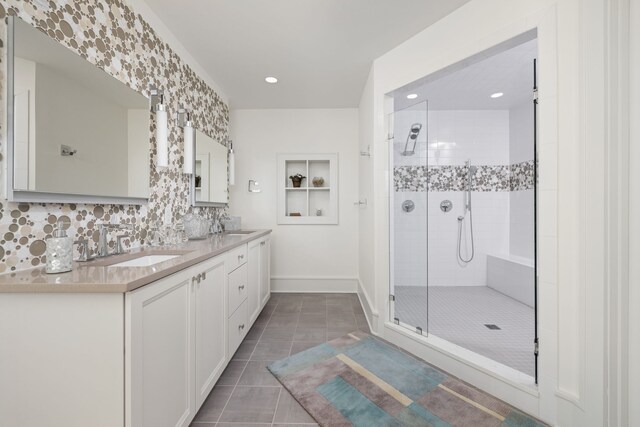 bathroom with tile patterned flooring, a sink, a shower stall, decorative backsplash, and double vanity