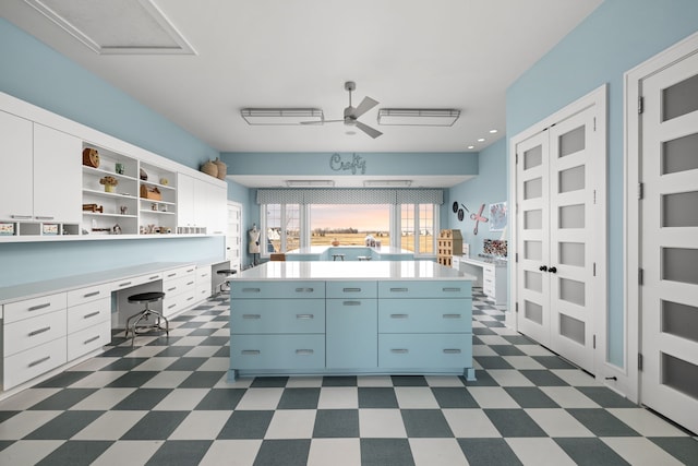 kitchen featuring dark floors, open shelves, built in desk, and light countertops