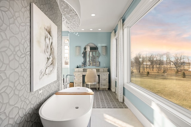 full bathroom featuring tile walls, a freestanding bath, and recessed lighting