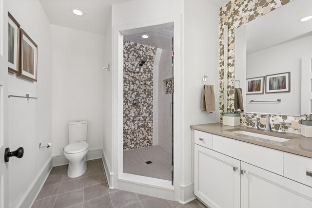 full bath featuring toilet, a shower stall, vanity, tile patterned flooring, and baseboards