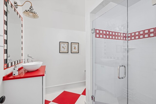 bathroom with a shower stall, baseboards, and vanity