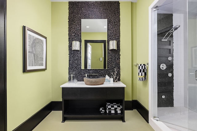 full bath with a stall shower, vanity, and baseboards