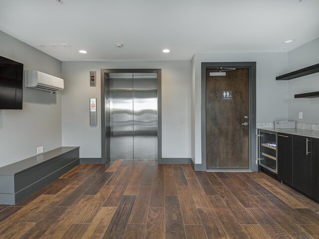 kitchen with elevator, an AC wall unit, and dark wood-type flooring