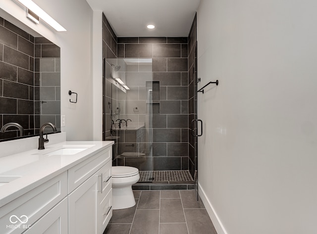 bathroom featuring tile patterned flooring, vanity, a shower with shower door, and toilet