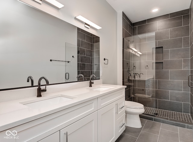 bathroom with tile patterned floors, vanity, toilet, and a shower with door