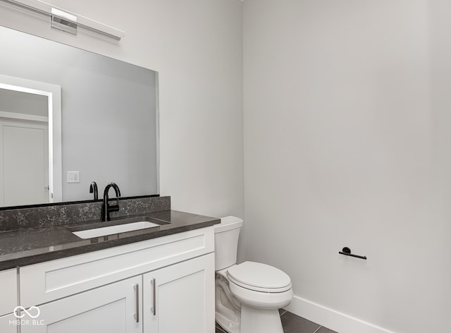 bathroom featuring toilet, vanity, and tile patterned floors