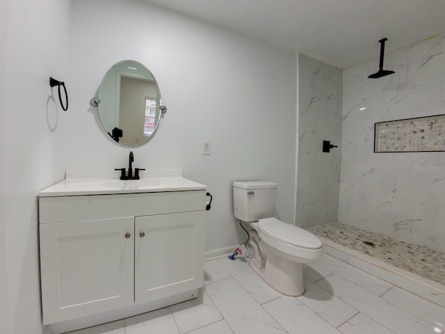 bathroom with vanity, tiled shower, toilet, and tile patterned floors