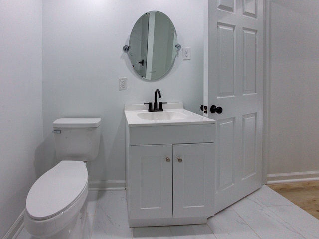 bathroom with vanity, wood-type flooring, and toilet