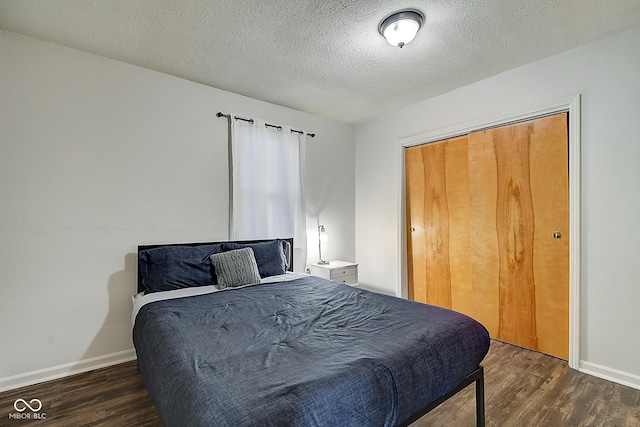 bedroom featuring a textured ceiling, baseboards, and wood finished floors