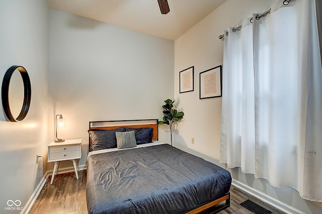 bedroom with visible vents, ceiling fan, baseboards, and wood finished floors