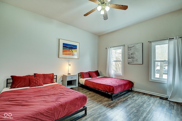 bedroom with a ceiling fan, baseboards, and wood finished floors