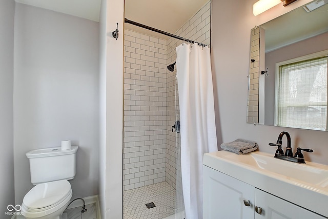 bathroom featuring toilet, a stall shower, baseboards, and vanity