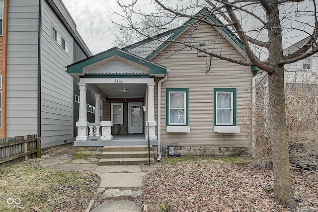 view of front of property with covered porch and fence