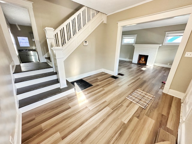 stairs featuring wood-type flooring and crown molding