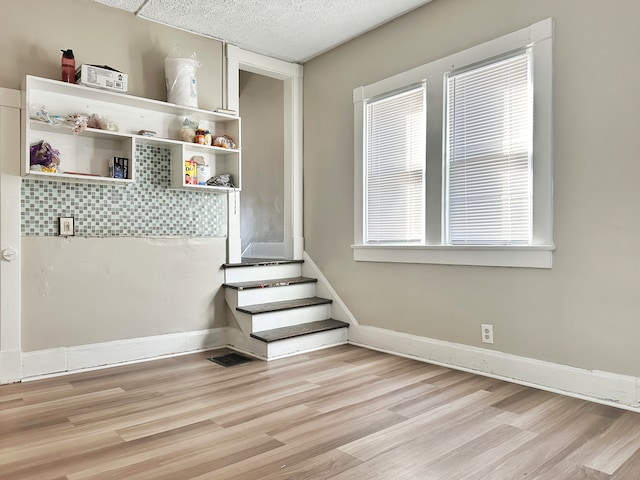 interior space with a textured ceiling and light hardwood / wood-style flooring