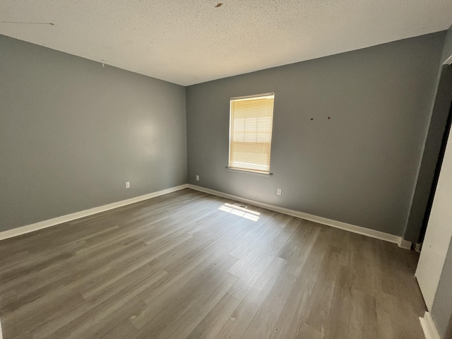 empty room featuring a textured ceiling and hardwood / wood-style floors