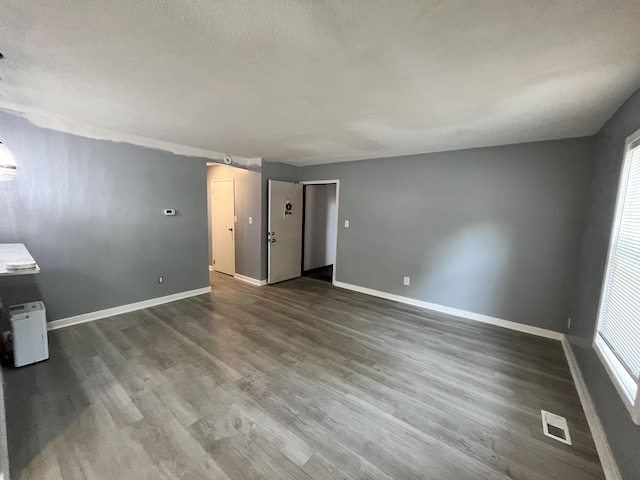 spare room with a textured ceiling and hardwood / wood-style floors