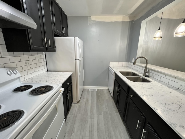 kitchen featuring white appliances, pendant lighting, light hardwood / wood-style floors, decorative backsplash, and sink