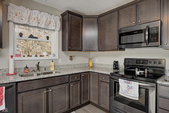 310 Jefferson, Coatesville, IN 46121 - kitchen with stainless steel appliances, a sink, dark brown cabinetry, light stone counters, and a textured ceiling