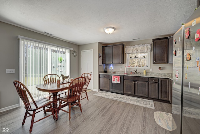 310 Jefferson, Coatesville, IN 46121 - dining space with baseboards, light wood-style flooring, a textured ceiling, and wet bar