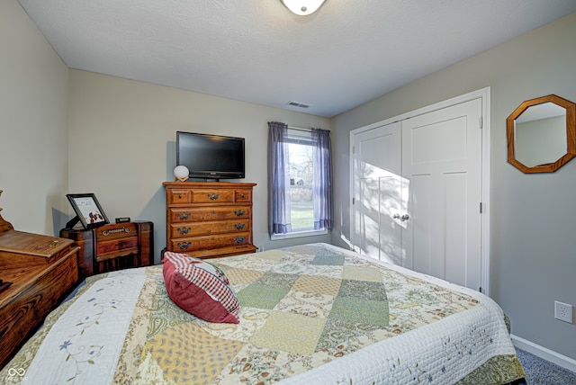 bedroom with a closet, carpet floors, and a textured ceiling