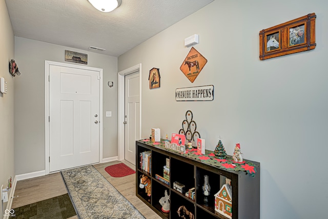 foyer with wood-type flooring and a textured ceiling