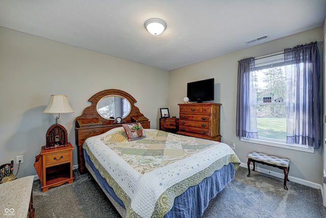 bedroom with carpet floors and a textured ceiling