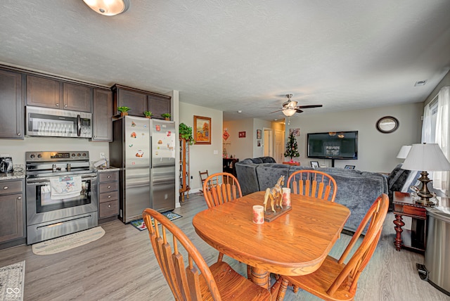 dining area featuring ceiling fan, light hardwood / wood-style floors, and a textured ceiling