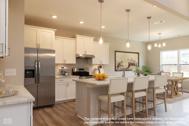 kitchen featuring white cabinets, appliances with stainless steel finishes, and a kitchen island with sink