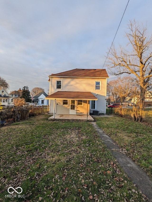 rear view of property with a yard and a porch