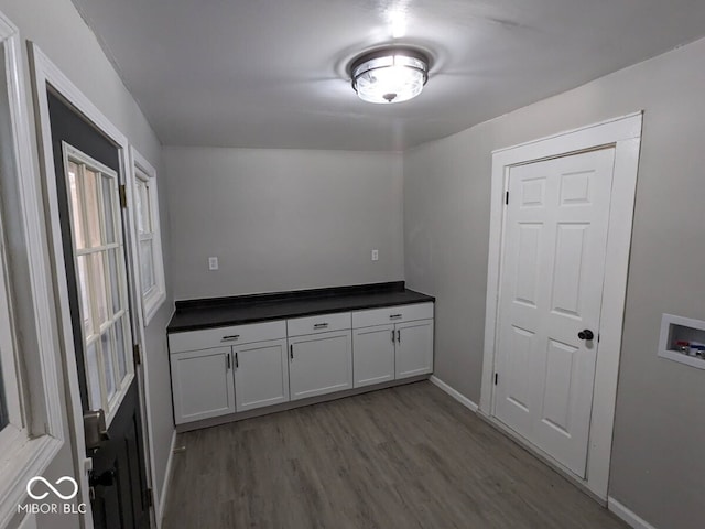 laundry room with washer hookup, cabinets, and light wood-type flooring