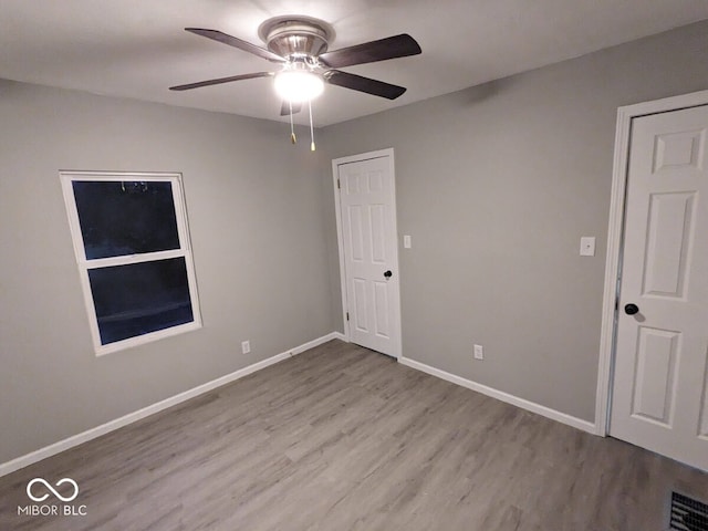 spare room with light wood-type flooring and ceiling fan