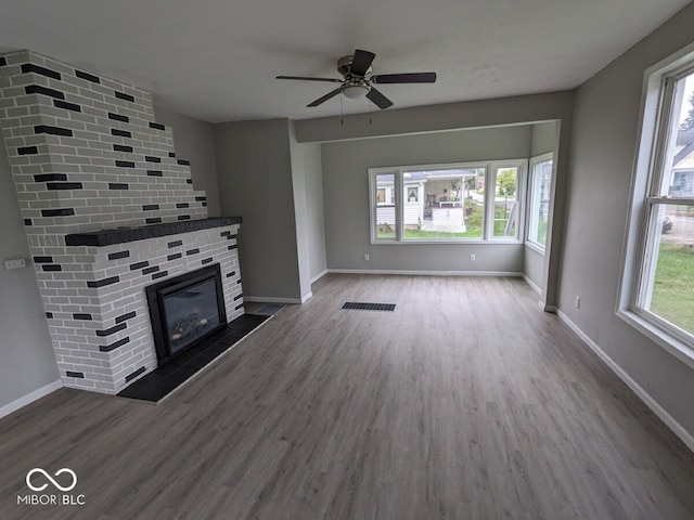 unfurnished living room with a wealth of natural light, hardwood / wood-style flooring, and a fireplace