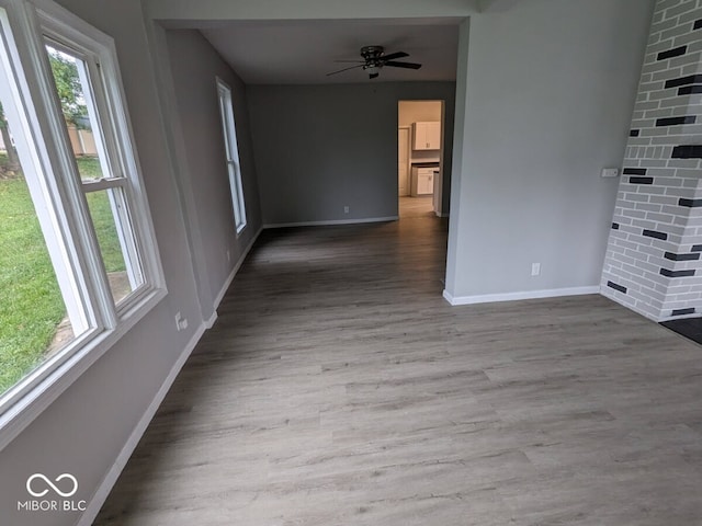 unfurnished room with a wealth of natural light, ceiling fan, and hardwood / wood-style floors