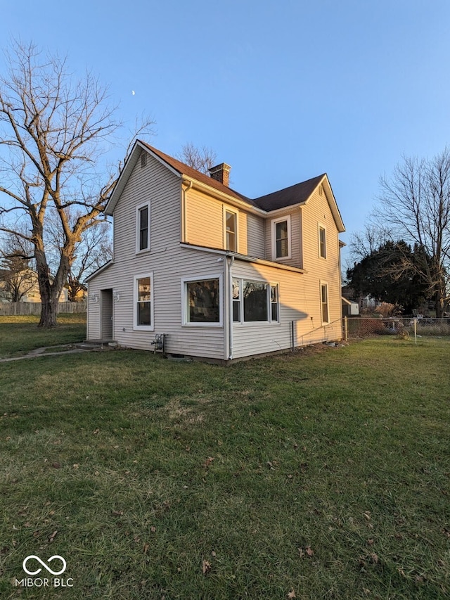 rear view of property featuring a lawn