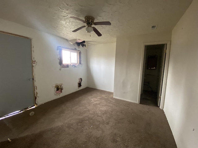 carpeted spare room featuring ceiling fan and a textured ceiling