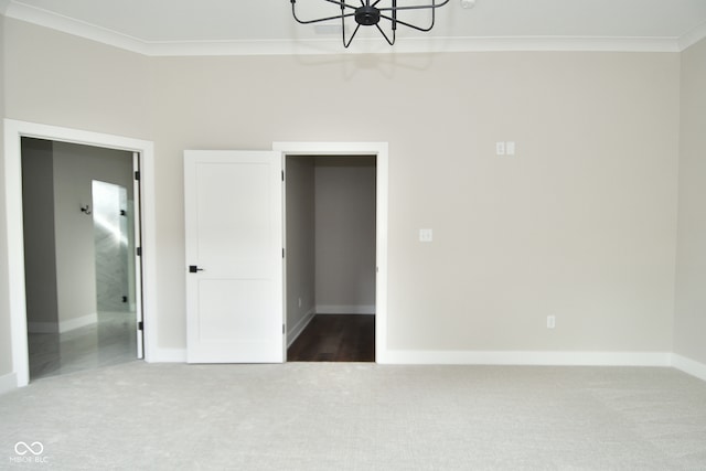 unfurnished bedroom with ornamental molding, carpet flooring, and a chandelier