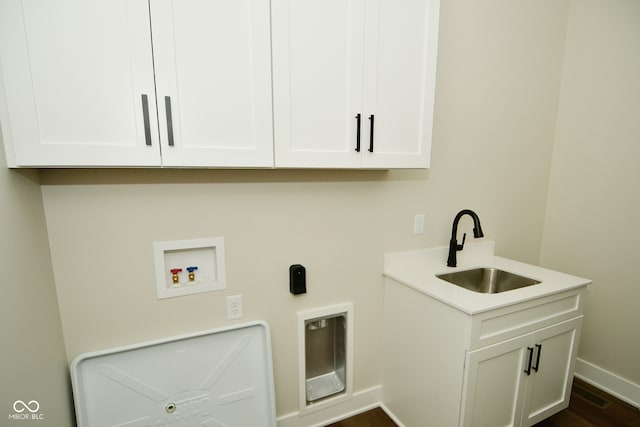 washroom featuring cabinets, washer hookup, sink, and dark wood-type flooring