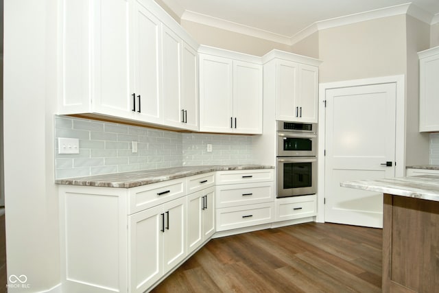 kitchen with white cabinetry, dark hardwood / wood-style floors, double oven, and light stone countertops