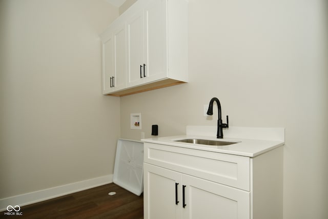 laundry area with cabinets, hookup for a washing machine, sink, and dark hardwood / wood-style flooring