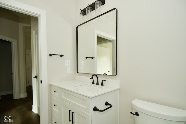 bathroom with hardwood / wood-style floors, vanity, and toilet