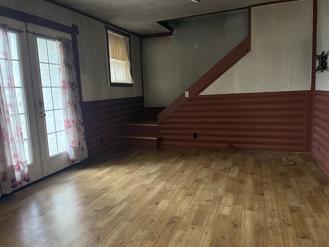 unfurnished living room featuring french doors and light hardwood / wood-style floors