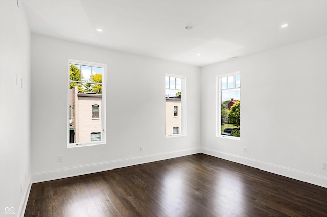 unfurnished room with dark wood-type flooring