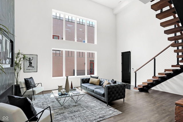 living room with a towering ceiling and wood-type flooring