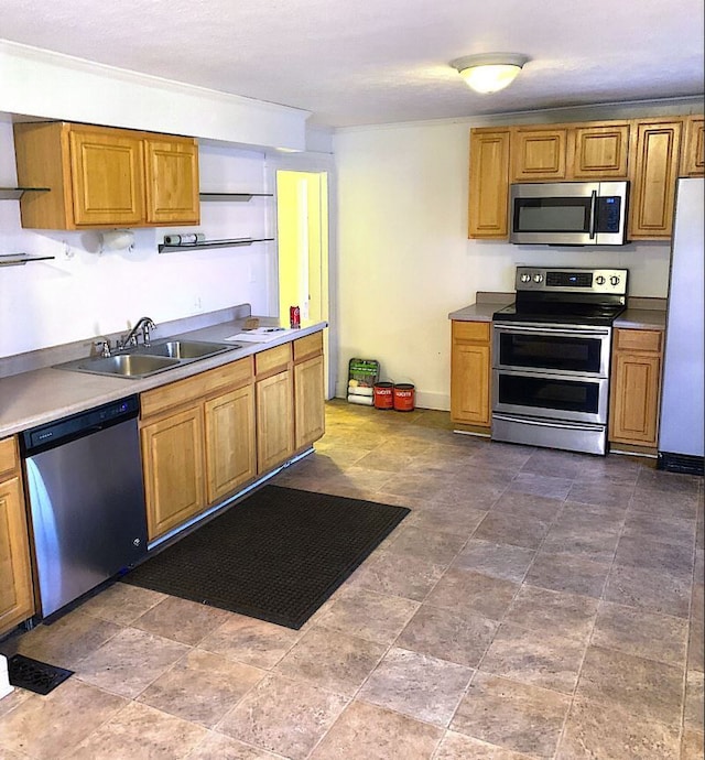 kitchen with dark tile flooring, sink, and stainless steel appliances