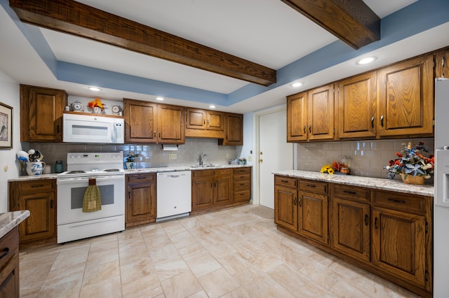 kitchen with beam ceiling, tasteful backsplash, sink, and white appliances