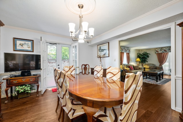 dining space featuring french doors, an inviting chandelier, dark hardwood / wood-style floors, a textured ceiling, and ornamental molding